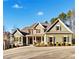 Charming two-story home showcasing stone accents, green siding, and manicured landscaping at 121 Harmony Oaks Trl, Canton, GA 30115