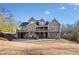 View of the rear exterior of a home with a large yard, deck, and covered patio at 121 Harmony Oaks Trl, Canton, GA 30115