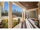 Spacious covered porch featuring wood decking, views of nature, and charming light fixtures at 121 Harmony Oaks Trl, Canton, GA 30115