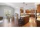 Open kitchen with wood cabinets, granite counters, stainless appliances, and a central island at 121 Harmony Oaks Trl, Canton, GA 30115