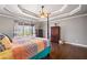 Comfortable bedroom featuring a tray ceiling, natural light, and warm color accents at 121 Harmony Oaks Trl, Canton, GA 30115