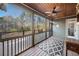 View of a screened-in porch with wooden flooring, a ceiling fan, and wooded scenery at 121 Harmony Oaks Trl, Canton, GA 30115