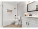 Bright white bathroom with a shower over the tub and a single sink vanity at 2002 Country Park Se Dr, Smyrna, GA 30080