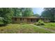 Charming single-story home featuring a brick exterior and a spacious front yard with mature trees and a stone pathway at 2886 The Fontainebleau Sw, Atlanta, GA 30331