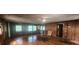 Spacious living room with hardwood floors, wood-paneled walls, and natural light from multiple windows, adjacent to the kitchen at 2886 The Fontainebleau Sw, Atlanta, GA 30331