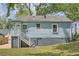 Side of the blue bungalow with exterior access to unfinished basement space and yard at 1002 Ira Sw St, Atlanta, GA 30310