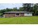 View of the back exterior featuring a brick facade and a well-manicured lawn at 1091 Luther Sw Dr, Mableton, GA 30126