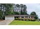 Charming brick home featuring an attached garage and a well-manicured front yard with lush green lawn at 1091 Luther Sw Dr, Mableton, GA 30126