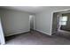 Living room featuring neutral-toned walls, carpeted flooring, and a door to another room at 1091 Luther Sw Dr, Mableton, GA 30126