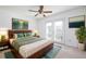 Bedroom featuring a wood-frame bed, wood floors, a large plant, and double doors to the exterior at 1468 Briarwood Ne Rd # 2003, Atlanta, GA 30319