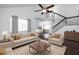 Bright living room with high ceilings, ceiling fan, plush sofas, dark wood floors, and a view into the dining room at 1468 Briarwood Ne Rd # 2003, Atlanta, GA 30319