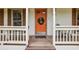 Inviting front porch with an orange door, wreath, chairs and charming decor at 1768 San Andra Dr, Marietta, GA 30062