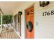 Inviting porch with a swing, exterior shutters, and an orange front door at 1768 San Andra Dr, Marietta, GA 30062
