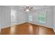 Bedroom with hardwood floors, white walls, ceiling fan, and sunlit windows at 4440 Coventry Ne Ct, Roswell, GA 30075