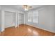 Bedroom featuring hardwood floors, a ceiling fan, closet, and a double window for natural light at 4440 Coventry Ne Ct, Roswell, GA 30075