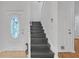 Entryway featuring dark-stained stairs, white walls, and an arched front door at 4440 Coventry Ne Ct, Roswell, GA 30075
