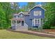 Charming blue two-story home featuring a welcoming front porch and lush, landscaped front yard at 4440 Coventry Ne Ct, Roswell, GA 30075