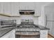 Well-equipped kitchen features a gas range, microwave, and stainless steel refrigerator at 4440 Coventry Ne Ct, Roswell, GA 30075