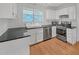 Well-equipped kitchen featuring stainless steel appliances, hardwood floors, and white cabinets at 4440 Coventry Ne Ct, Roswell, GA 30075