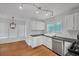 Bright kitchen features white cabinetry, stainless steel appliances, track lighting, and wood flooring at 4440 Coventry Ne Ct, Roswell, GA 30075