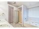 Bright bathroom featuring double sinks, a soaking tub, and a separate shower with glass door at 745 Birchberry Sw Ter, Atlanta, GA 30331