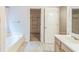 Bathroom featuring tub and view into a closet or dressing area for convenient storage at 745 Birchberry Sw Ter, Atlanta, GA 30331