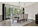 Bright dining room with modern light fixture, large windows, and hardwood flooring offers elegant space for gatherings and entertaining at 1626 Aldworth Se Pl, Atlanta, GA 30339