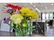 Vase of colorful flowers in the kitchen with kitchen island and eating area in the background at 1626 Aldworth Se Pl, Atlanta, GA 30339