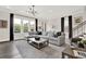Bright, open living room with large windows, modern light fixture, and comfortable gray sectional sofa at 1626 Aldworth Se Pl, Atlanta, GA 30339