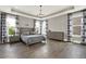 Spacious main bedroom featuring a tray ceiling, modern fixtures, and beautiful hardwood floors at 1626 Aldworth Se Pl, Atlanta, GA 30339