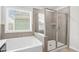 Bright bathroom with a soaking tub under a window and a separate shower with glass door at 3219 Colchester St, Douglasville, GA 30135