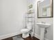 Bathroom featuring a modern pedestal sink, toilet, and wood flooring at 3219 Colchester St, Douglasville, GA 30135