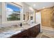 Well-lit bathroom features a granite counter, dual sinks, shower and tub, and large windows with a view at 3415 Trickum Rd, Woodstock, GA 30188