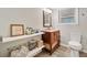 Bathroom featuring a wooden vanity, storage shelving, and a framed mirror with modern fixtures at 3415 Trickum Rd, Woodstock, GA 30188