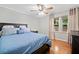 Bright bedroom with hardwood floors, ceiling fan, and large window for ample natural light at 3415 Trickum Rd, Woodstock, GA 30188