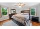 Cozy bedroom with large bed, dark wood furniture, neutral walls, and a ceiling fan with attached light at 3415 Trickum Rd, Woodstock, GA 30188