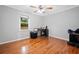 Bright bedroom featuring hardwood floors, base molding, window and ceiling fan at 3415 Trickum Rd, Woodstock, GA 30188