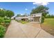 Long concrete driveway leading to a well-maintained home, carport, and meticulously landscaped yard at 3415 Trickum Rd, Woodstock, GA 30188