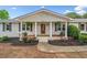Beautiful white brick house with a red front door, covered porch, and meticulously landscaped yard at 3415 Trickum Rd, Woodstock, GA 30188