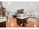 Modern kitchen with stainless steel appliances, dark wood cabinets, and an island open to the living area at 3415 Trickum Rd, Woodstock, GA 30188