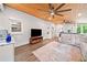Bright living room with white brick walls, wood ceiling with ceiling fans, and an adjacent kitchenette at 3415 Trickum Rd, Woodstock, GA 30188