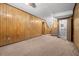 Spacious basement featuring wood paneling, carpet and stairs to the main level at 6100 Prestige Valley Rd, Morrow, GA 30260