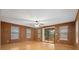 Cozy living room featuring wood paneling, a ceiling fan, and sliding glass doors at 6100 Prestige Valley Rd, Morrow, GA 30260