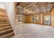 Unfinished basement with exposed wooden framing, stairs, and a door leading outside at 739 Marlay Sw Ln, Powder Springs, GA 30127