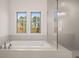 Bright bathroom featuring a soaking tub, walk-in shower, and double windows at 739 Marlay Sw Ln, Powder Springs, GA 30127