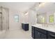 Bathroom with glass shower, double vanities with modern fixtures, and large windows at 739 Marlay Sw Ln, Powder Springs, GA 30127