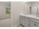 Bright bathroom with double vanity, white cabinetry, and a glimpse into the bedroom at 739 Marlay Sw Ln, Powder Springs, GA 30127