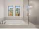 Luxurious bathroom with a soaking tub under a bright window and a large, glass-enclosed shower at 739 Marlay Sw Ln, Powder Springs, GA 30127