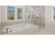 Bright bathroom featuring a soaking tub, large shower with glass enclosure, and natural light from three windows at 739 Marlay Sw Ln, Powder Springs, GA 30127