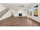 This spacious living room features a fireplace, large windows offering scenic views, hardwood floors, and stairs at 739 Marlay Sw Ln, Powder Springs, GA 30127